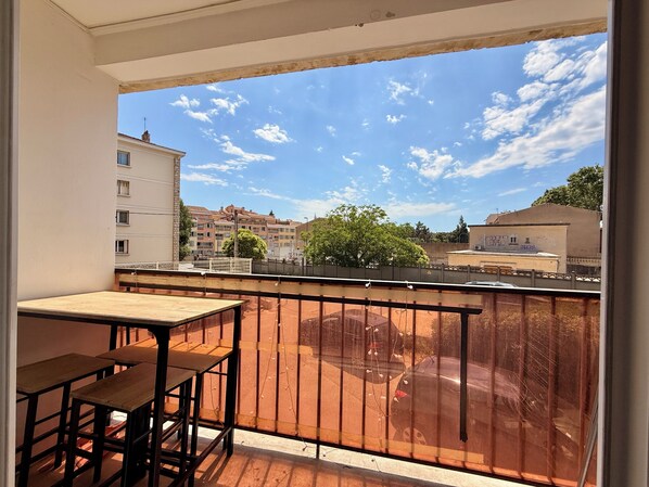 A balcony with a table and chairs, a view of buildings, and a clear sky. - Two-bedroom apartment within a 10-minute walk of downtown (Aix-en-Provence)