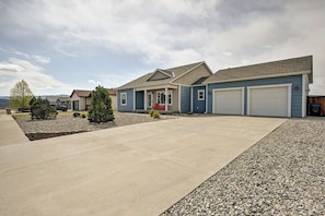 A residential property with a driveway, a covered porch, and a garage.