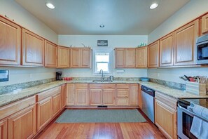 A kitchen with wooden cabinets, granite countertops, a dishwasher, and a built-in oven.