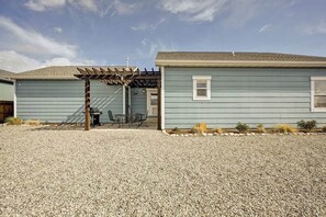 A single-story house with a covered patio area and a gravel driveway.