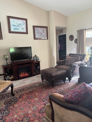 A living room with a fireplace, a television, and a sofa.