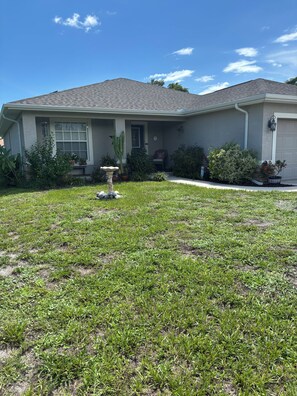 A residential house with a front yard, a driveway, and a garage. - 3-bedroom house in Rotonda West  golfing, beaches, fishing, shopping, Disney (Rotonda West)