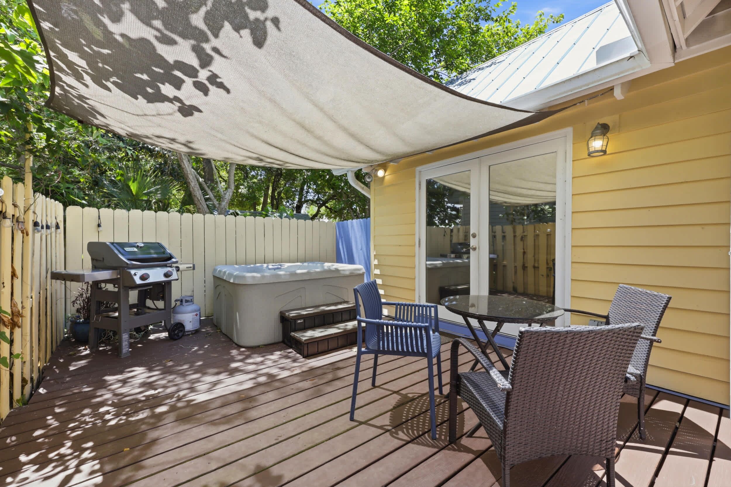 A patio with a grill, hot tub, and outdoor seating.
