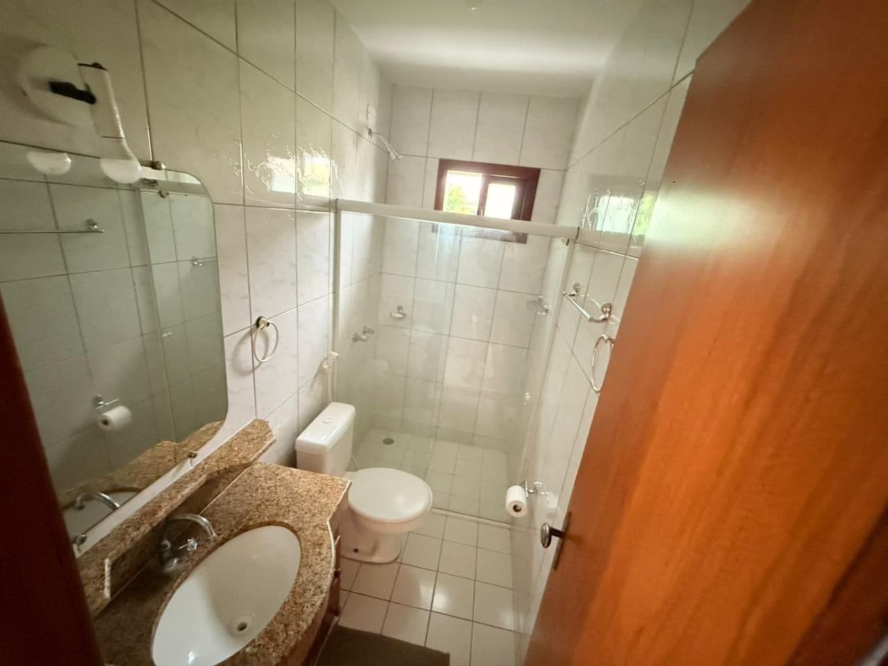 Een badkamer met een wastafel, toilet en douchehoek.