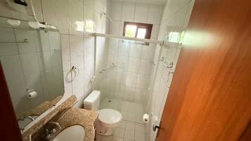 Een badkamer met een wastafel, toilet en douchehoek.