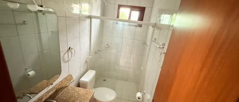 Casa de banho com lavatório, sanita e zona de duche.