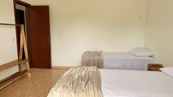 Ein Zimmer mit zwei Betten, einer Holzleiter und einer Tür.