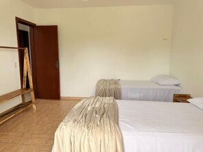 A room with two beds, a wooden ladder, and a door. - CASA 4 QUARTOS (Porto Seguro)