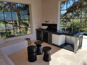 A modern kitchen with large windows, a black countertop, and a white refrigerator. - A CONTEMPORARY VILLA WITH AN EXCEPTIONAL PANORAMA (La Croix-Valmer)