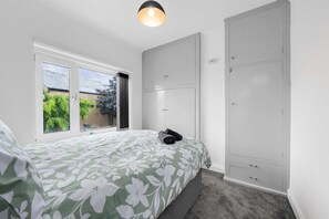 Une chambre à coucher avec un lit, une armoire et une fenêtre.