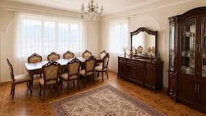 A dining room with a wooden table and chairs, a chandelier, a cabinet with glass doors, and a patterned rug. - Spacious Forest Guesthouse in Vanadzor for Families & Groups (Vanadzor)