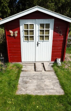 A red shed with a white door, two windows, a butterfly decoration, and an owl decoration. - A Swedish-style house with horses and a canoe trail right outside the door (Värmland County)