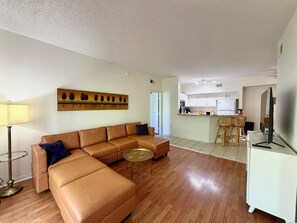 Ein Wohnzimmer mit einer Couch, einem runden Couchtisch und einem Bild an der Wand.