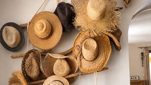 A variety of woven hats and woven baskets displayed on a wooden shelf and wall. - Provençal villa with pool, ocean views, and walking distance to the beach, sleeps 10, Giens Peninsula (Hyères)
