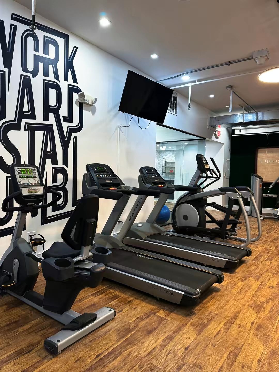 Une salle de sport équipée de tapis de course, d’un vélo elliptique et d’un vélo d’appartement.