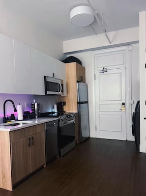 A modern kitchen with a microwave, refrigerator, oven, and sink.