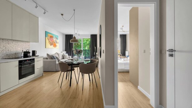 Eine moderne Küche mit Essbereich, einer Couch und Blick ins Freie.