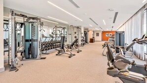 Ett gym med konditionsmaskiner, styrketräningsutrustning och hantlar.