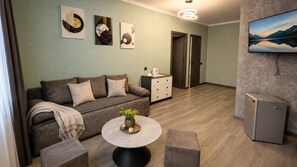 Un salon moderne avec un canapé, une table basse et des œuvres d’art accrochées au mur.