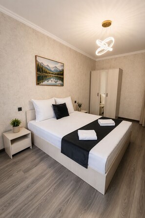 Une chambre à coucher avec un lit, une table de chevet, une armoire et un tableau au mur.