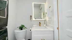 Een kleine badkamer met toilet, wastafel en spiegel.