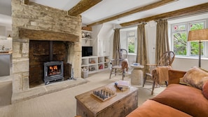 A cozy living room with a stone fireplace, a television, a chessboard, and comfortable seating. - Rose Cottage Oddington - Countryside  Retreat, 2 bedroom, Lower Oddington (Oddington)