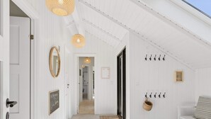 A hallway with white walls, a bench, a door, and a mirror. - 4 Star Holiday Home in Rorvig (Rørvig)