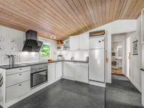 A modern kitchen with white cabinetry, a built-in oven, and a microwave. - "Wigman" - 450m to the fjord by Interhome (Tarm)