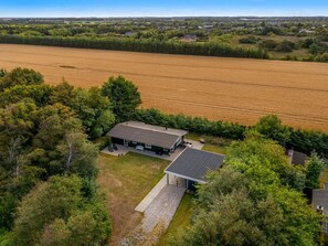 Una casa moderna con un campo extenso al fondo.