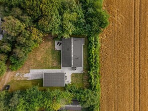 A residential property with a two-story house, a detached garage, and a large field adjacent to the property. - "Wigman" - 450m to the fjord by Interhome (Tarm)