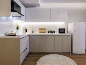 A modern kitchen with a built-in microwave, a coffee maker, and a refrigerator. - Cihangir Apartment - Sleeps 6 - Walk to Galata (Istanbul)