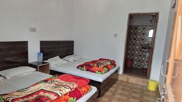 A room with two beds, a nightstand, a water bottle, and a bathroom visible through an open door.