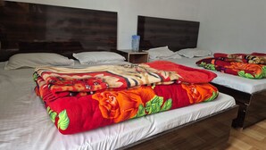 Een hotelkamer met een groot bed, twee nachtkastjes en een hoofdeinde.