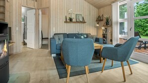 Ein modernes Wohnzimmer mit einer Couch, Sesseln, einem Couchtisch und einem Kamin.