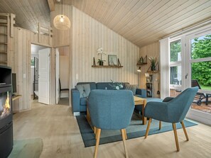 Una sala de estar moderna con sofá, sillones, mesa de centro y chimenea.