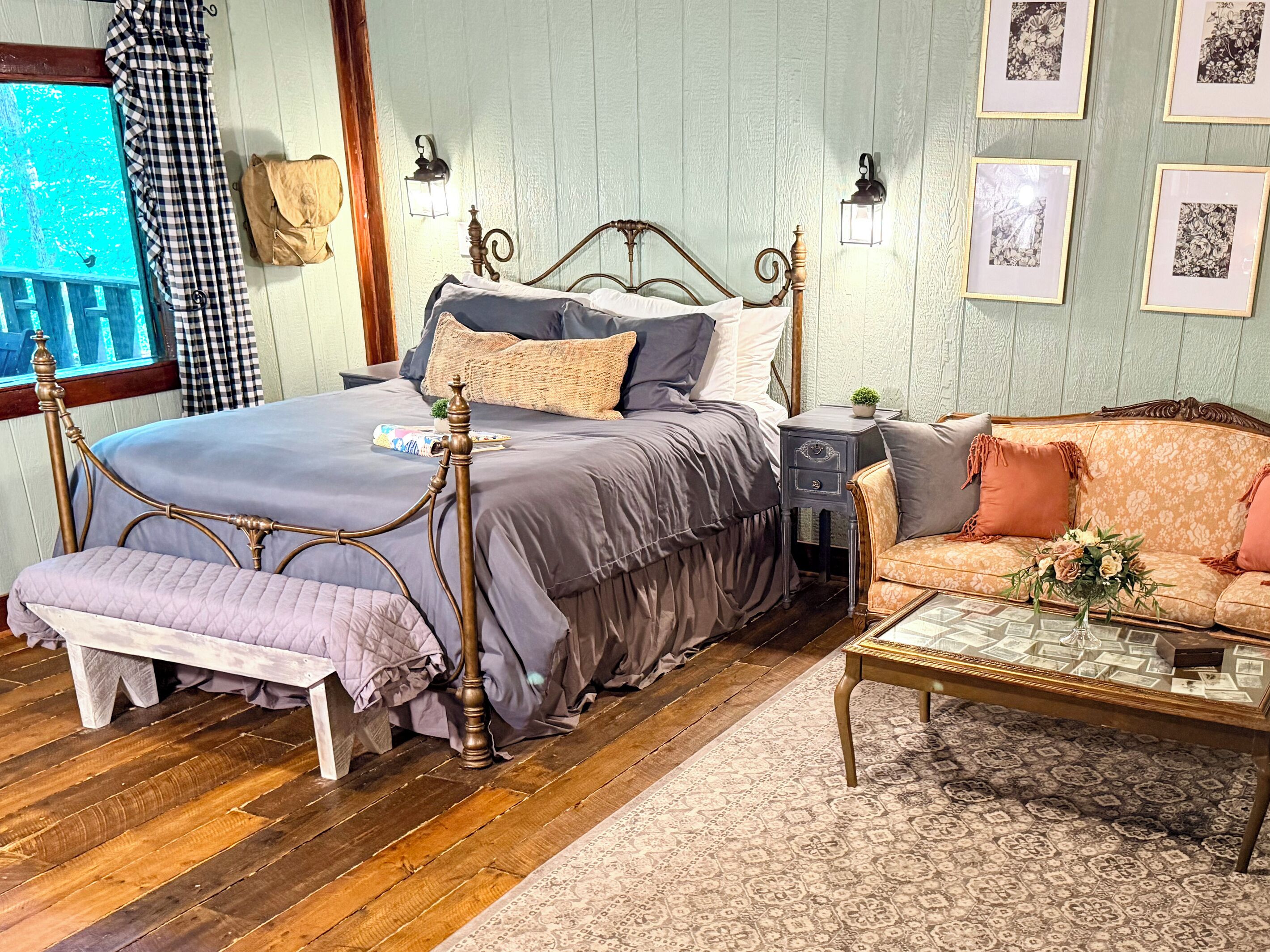 Un dormitorio con cama, mesita de noche y sofá.