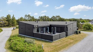 A modern two-story house with a covered patio, a driveway, and a grassy area with flowers. - "Bilal" - 1.8km from the sea by Interhome (Rømø)