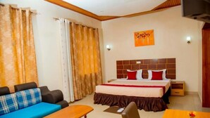 Una habitación de hotel con una cama, un sofá, un escritorio y una silla.