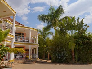 A two-story building with a balcony, surrounded by tropical vegetation. - Dana Kigali Hotel (Kigali)