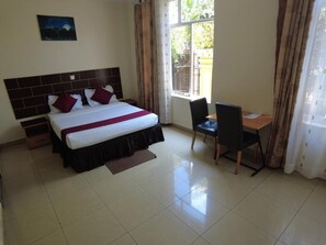 A hotel room with a bed, a desk, and a chair. - Dana Kigali Hotel (Kigali)