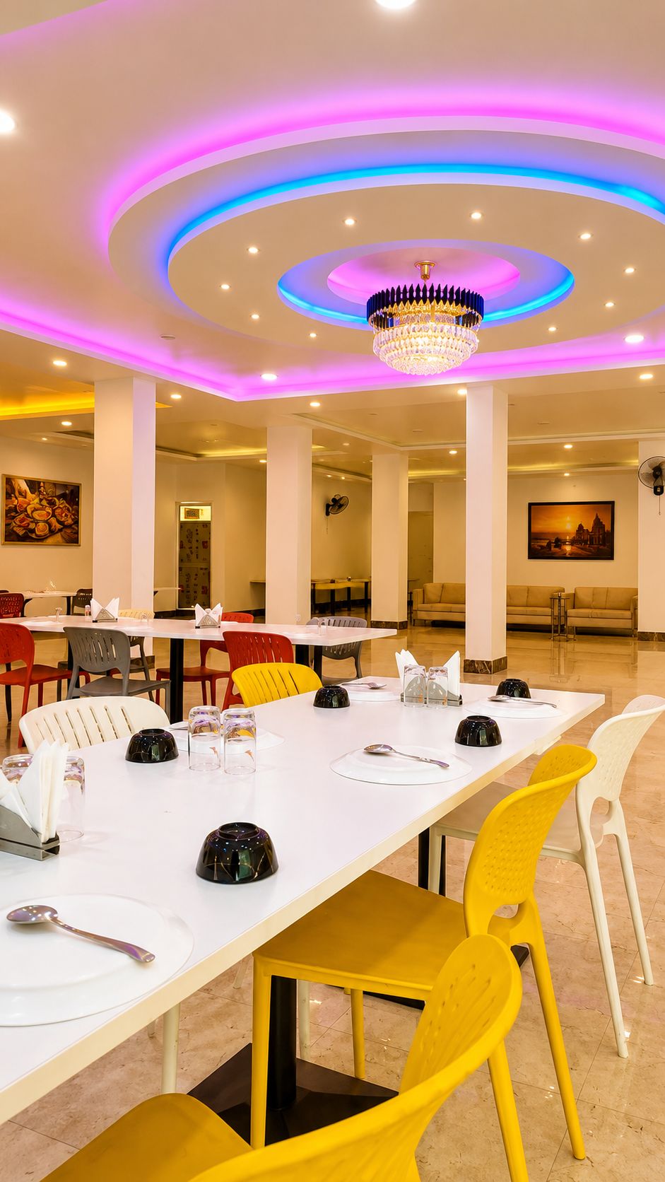 Un espace repas comprenant une longue table, plusieurs chaises et un lustre.