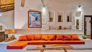 A modern interior with a sofa, a wooden coffee table, and a painting on the wall. - Beautiful 4-bedroom Villa with Private Pool close to Hotel Zone (Cancún)