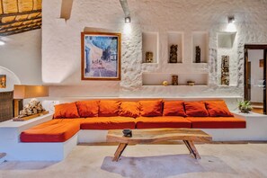 Ein modernes Interieur mit einer Couch, einem Holztisch und einem Gemälde an der Wand.
