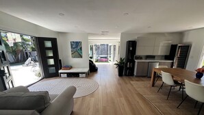 Un espacio habitable moderno con sofá, mesa de comedor y zona de cocina.