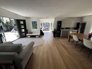 Ein moderner Wohnraum mit Sofa, Esstisch und Küchenzeile.