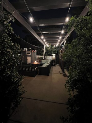 An outdoor patio area with a seating arrangement, a small table with a candle, and potted plants. - 3-bedroom house in perfect Encinitas with AC and Endless Pool (Encinitas)