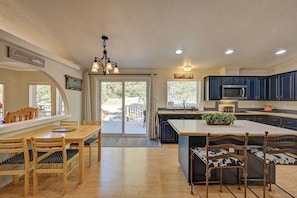 A spacious kitchen with a large island, wooden dining table, and chairs, and a view to the outside. - Bear's Den | Secluded, Pet-Friendly Getaway (Buena Vista)