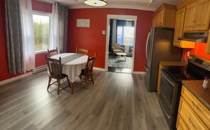 A kitchen with wooden cabinets, a stainless steel refrigerator, and a stove.
