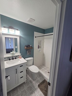 A bathroom with a white sink, a toilet, and a shower area. - 3-bedroom house in lovely Chassahowitzka with AC and a range of activities. (Homosassa)