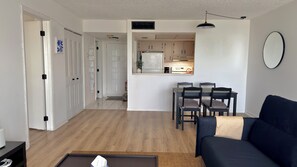 A living room with a dark sofa, a coffee table, and a dining area with a table and chairs. - Cozy 1-bedroom apartment in adorable Lauderhill with AC (Lauderhill)